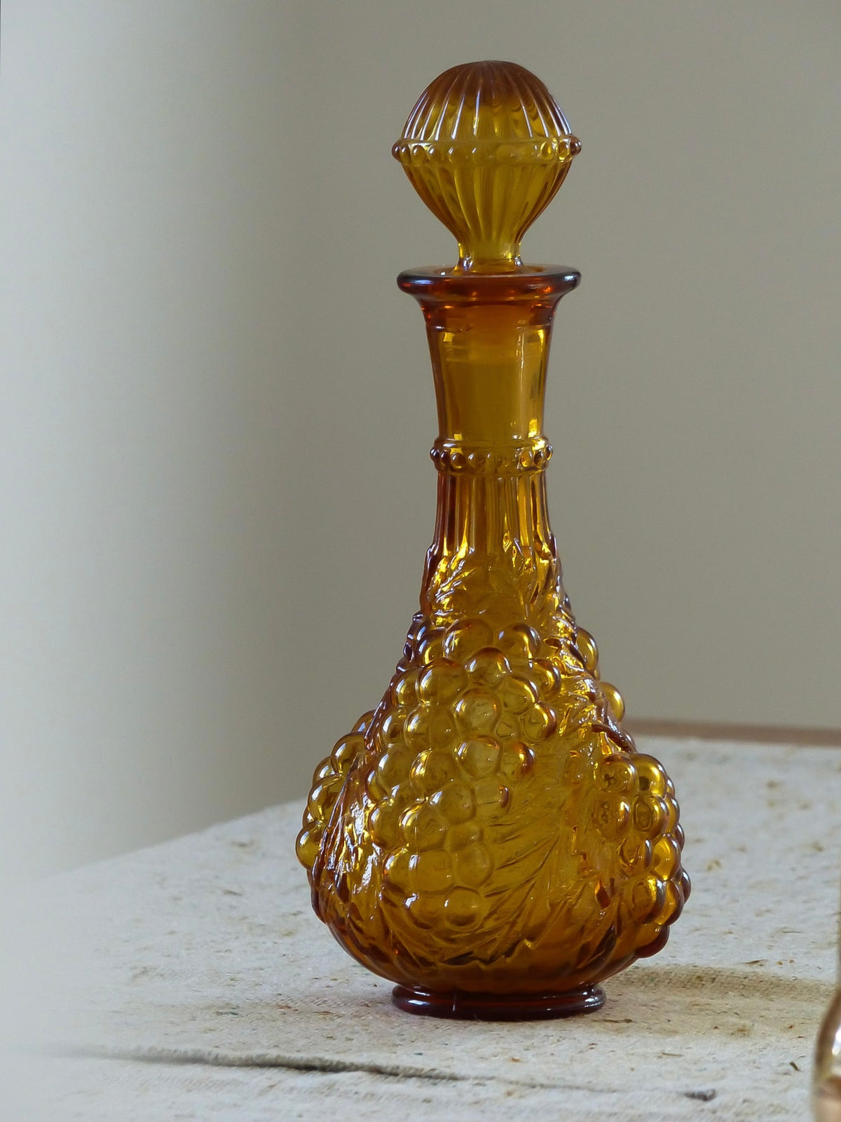 Bouteille vintage en verre ambré, relief en forme de grappes de raisin