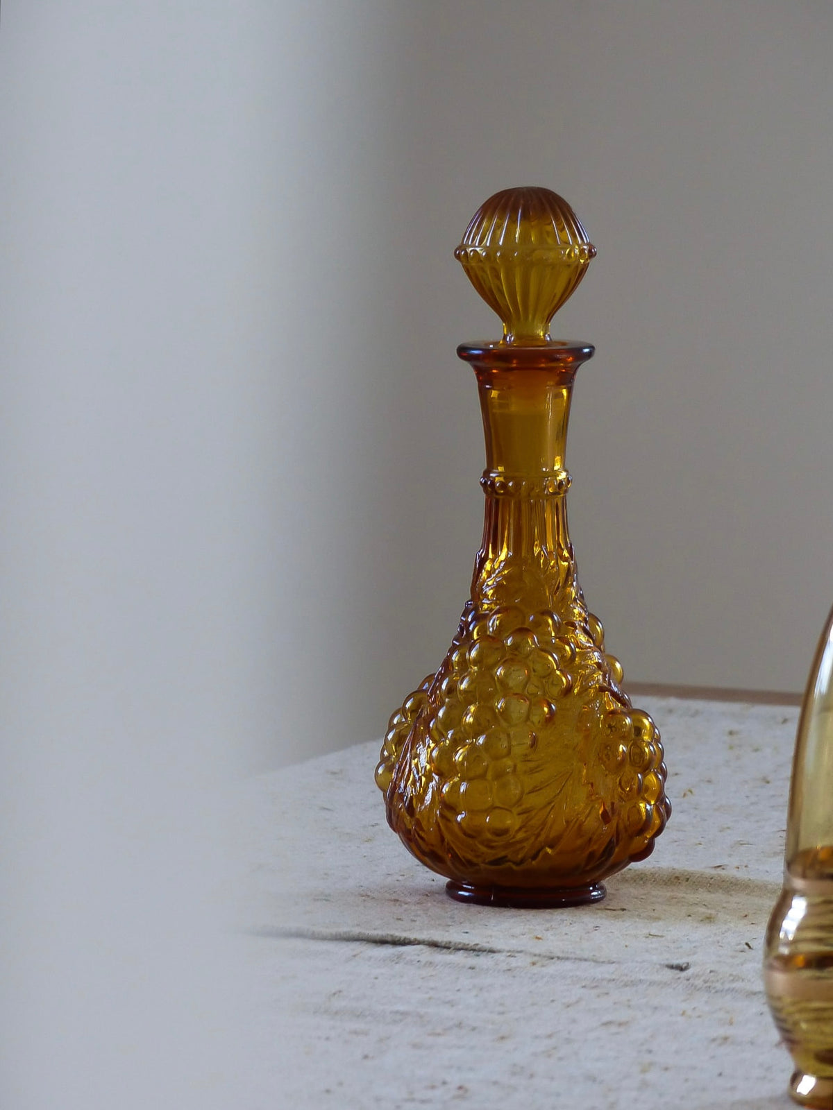 Bouteille vintage en verre ambré, relief en forme de grappes de raisin
