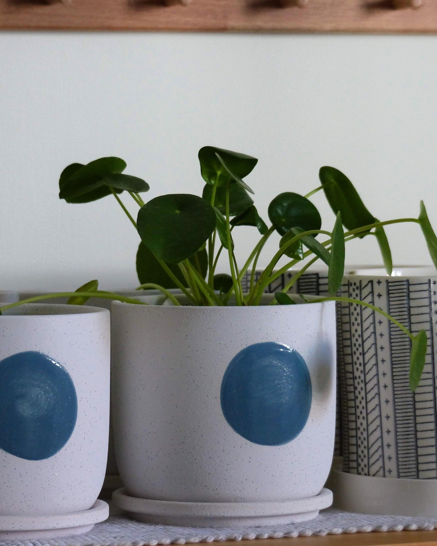 Pot en grès avec soucoupe et motif circulaire, blanc et bleu.